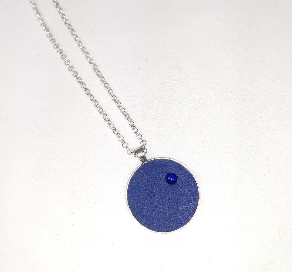 Vedhæng i messing og blåt læder med lapis lazuli cabochon.